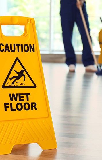 Safety sign and janitor mopping floor