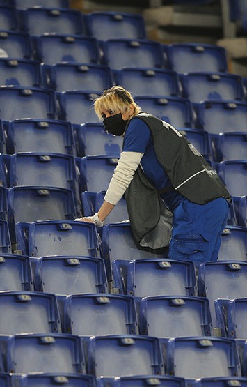 Cleaning lady cleans the stadium seats