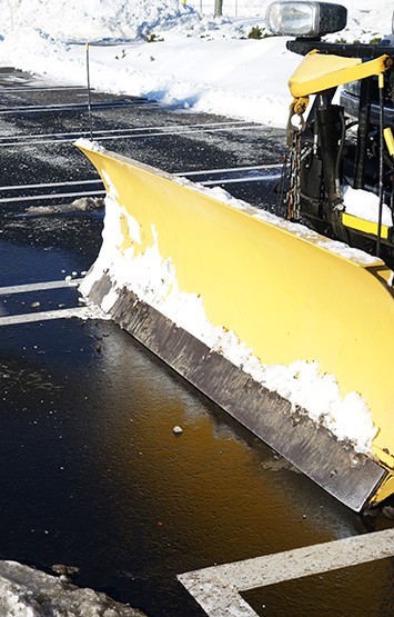 Snowplow in the parking lots with snow removed