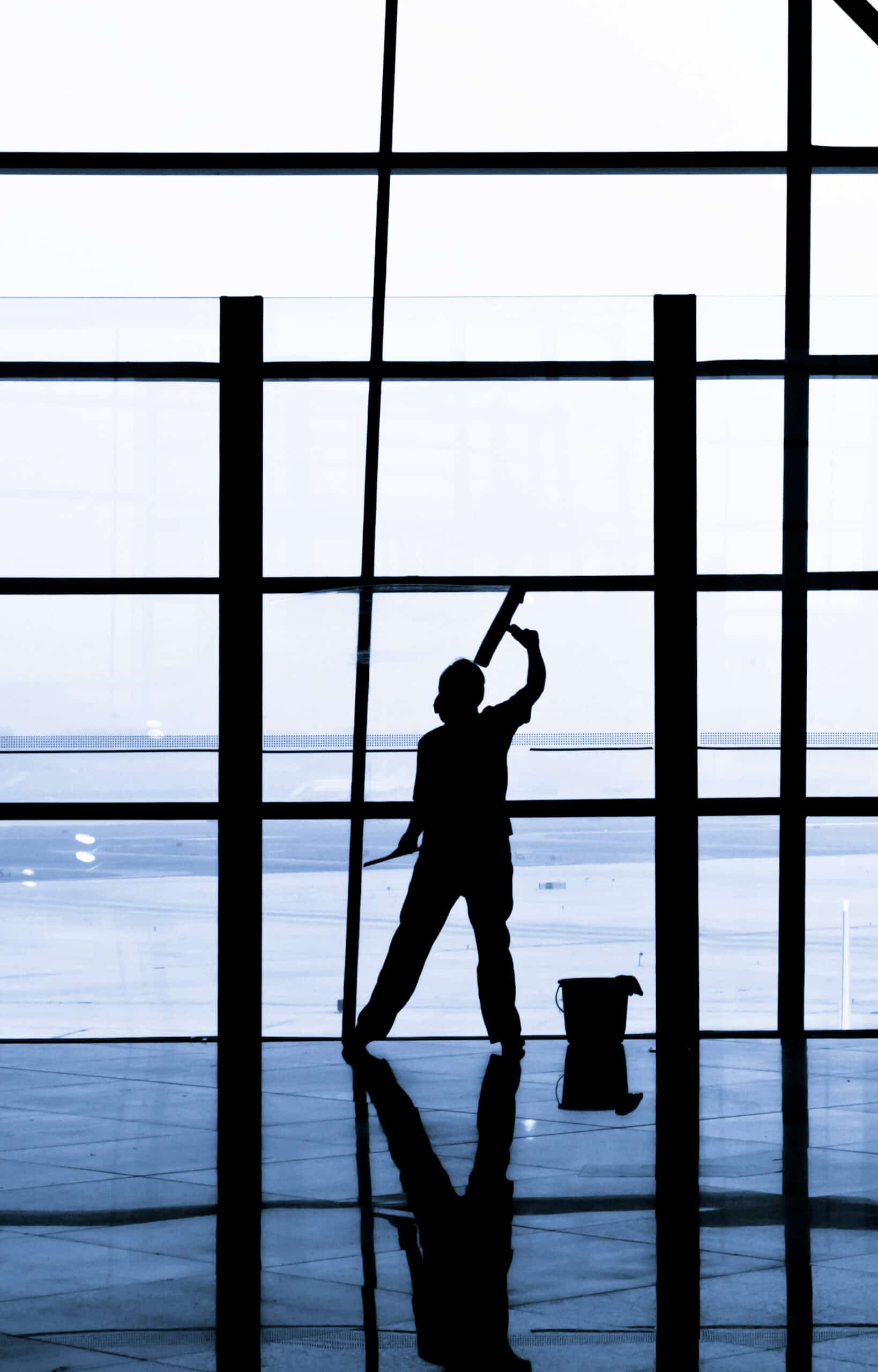 janitor cleaning windows at the airport